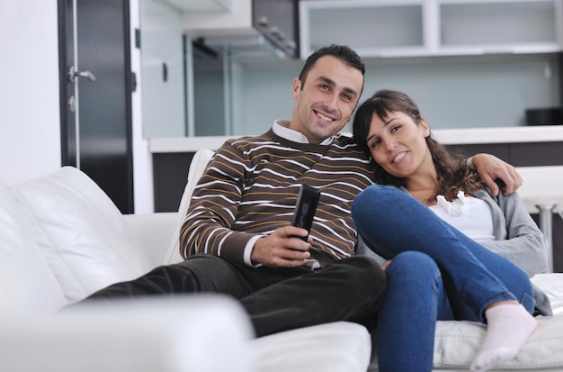 Una pareja joven relajada viendo la televisión en casa en un salón luminoso