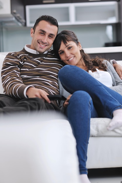 Una pareja joven relajada viendo la televisión en casa en un salón luminoso