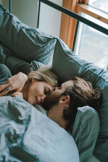 Una pareja joven relajándose en la cama en casa.