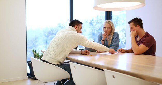 Una pareja joven y rica compra un apartamento, una propiedad, una casa, celebra un contrato con un agente inmobiliario. Firma un acuerdo con el vendedor.