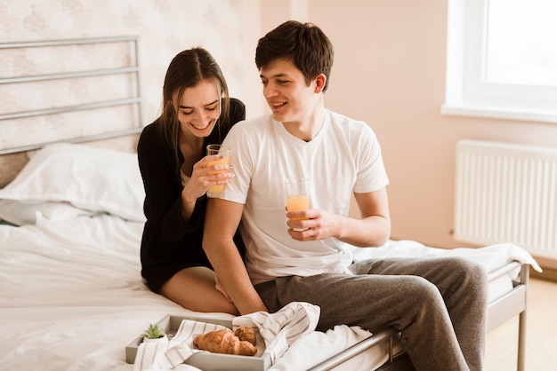 Pareja joven romántica desayunando en la cama