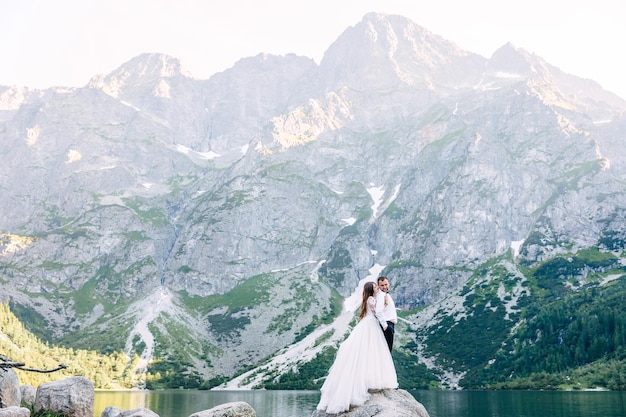 Una pareja joven romántica se encuentra en una piedra un hermoso lago A w