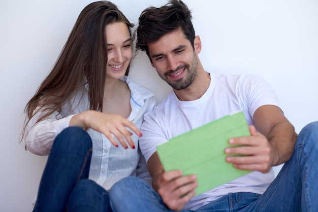 Una pareja joven romántica y relajada en una casa moderna usando una tableta