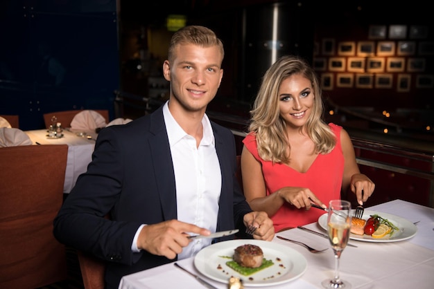 Pareja joven romántica en el restaurante comiendo comida