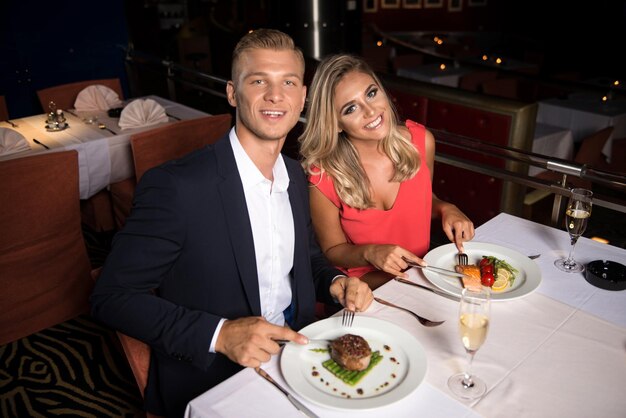 Pareja joven romántica en el restaurante comiendo comida