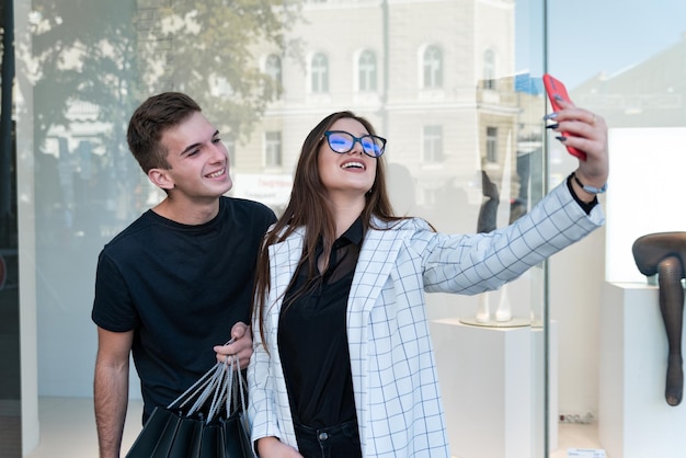 Pareja joven con ropa elegante hace selfie Chica se fotografía a sí misma contra su novio