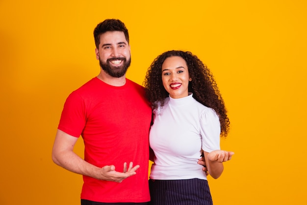 Pareja joven de San Valentín abrazados en retrato apuntando.