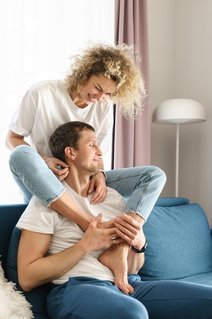 Pareja joven y sensual relajándose y pasando tiempo juntos en casa