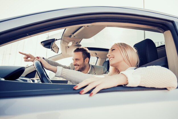 Pareja joven sentada en el coche