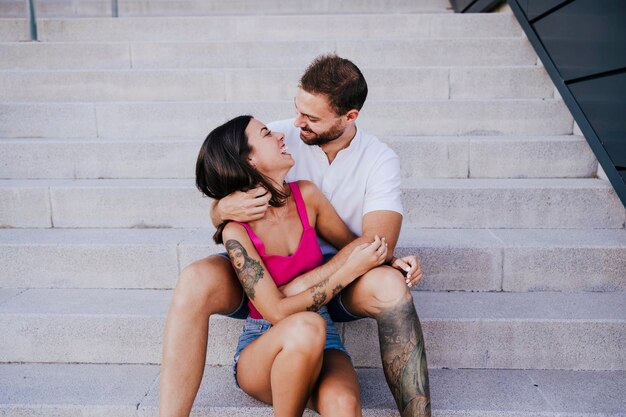 Foto una pareja joven sentada en la escalera