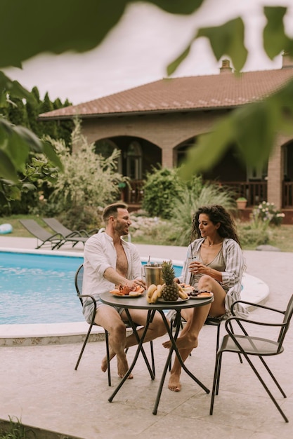 Pareja joven sentada en el patio trasero