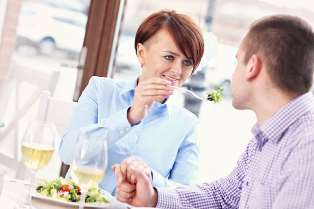 pareja joven sentada en un restaurante y comiendo