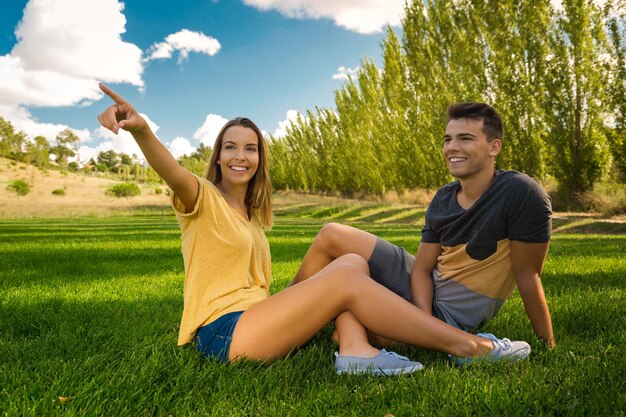 Foto una pareja joven sentada en tierra.