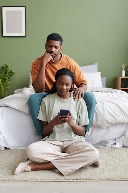 Pareja joven con smartphone en casa