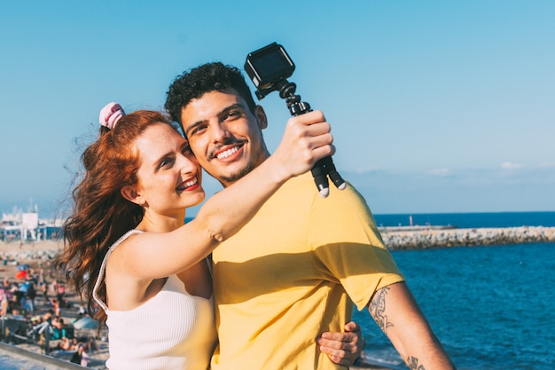 Pareja joven sonriendo tomar un selfie