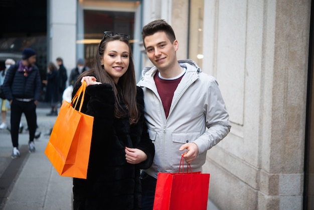 Pareja joven sonriente de compras en una calle urbana