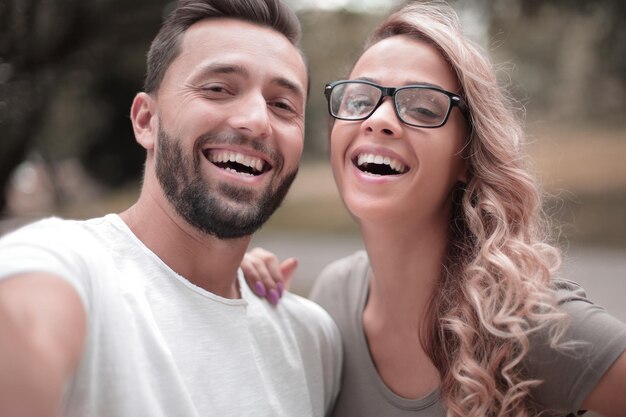 Pareja joven sonriente en el fondo del parque de la ciudad