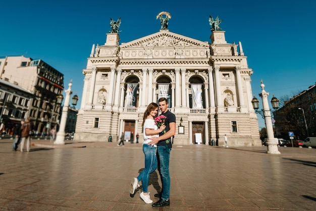 Pareja joven sonriente con un ramo de flores enamoradas se abrazan enamorados al aire libre Amor y ternura Fechado romance Concepto de estilo de vida