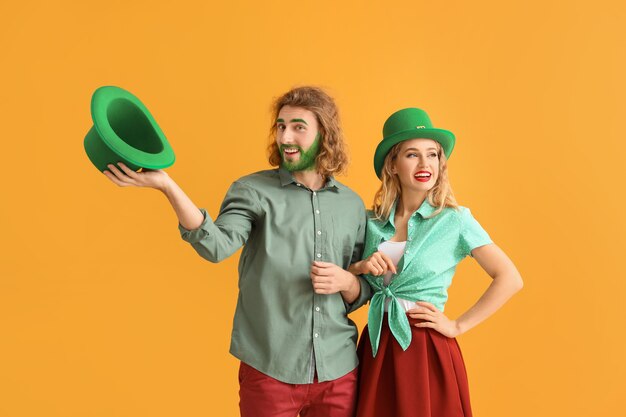 Pareja joven en la superficie de color. Celebración del día de San Patricio