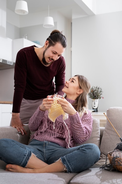 Pareja joven tejiendo juntos