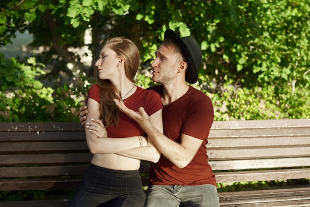 Pareja joven teniendo y argumento en un banco en un parque