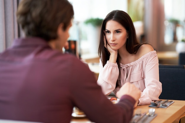 Pareja joven teniendo un problema y discutiendo en Cafe