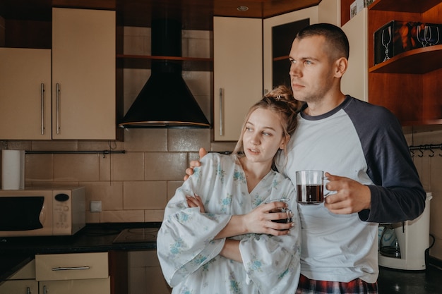 Pareja joven tomando café en la cocina en casa por la mañana joven pareja feliz recién casados familia