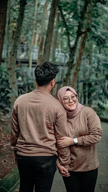 una pareja joven tomando una foto en un jardín de la ciudad