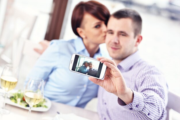 pareja joven tomando una foto en un restaurante