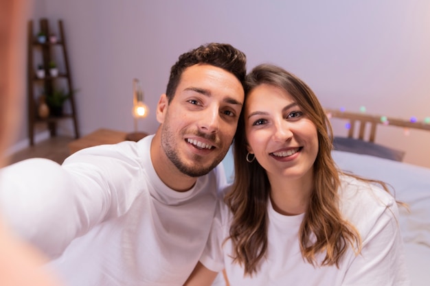 Foto pareja joven tomando selfie en dormitorio