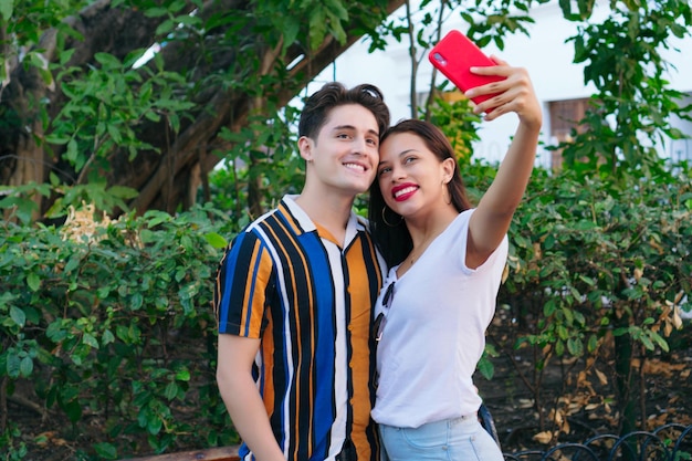 Pareja joven tomando selfie en el parque