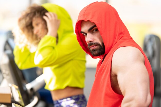 Pareja joven trabajando en el gimnasio haciendo ejercicio en las piernas Bicicleta de entrenamiento cardiovascular