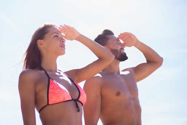 Pareja joven en traje de baño mirando al mar