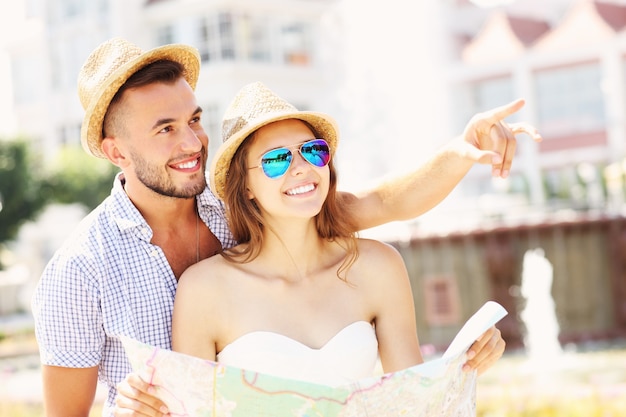 Pareja joven de turistas de pie con un mapa en Sopot.