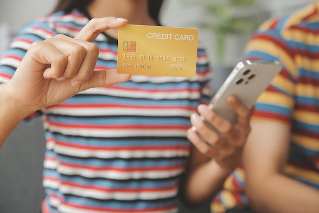 Pareja joven usa tarjeta de crédito para compras en línea en el sitio web de Internet en casa El número de la tarjeta de crédito es falso No se muestra información personal en la tarjeta de crédito Concepto de compras de negocios en línea