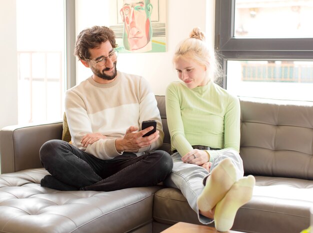 Pareja joven usando un teléfono inteligente en casa