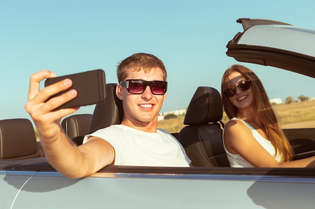 Pareja joven viajando en coche