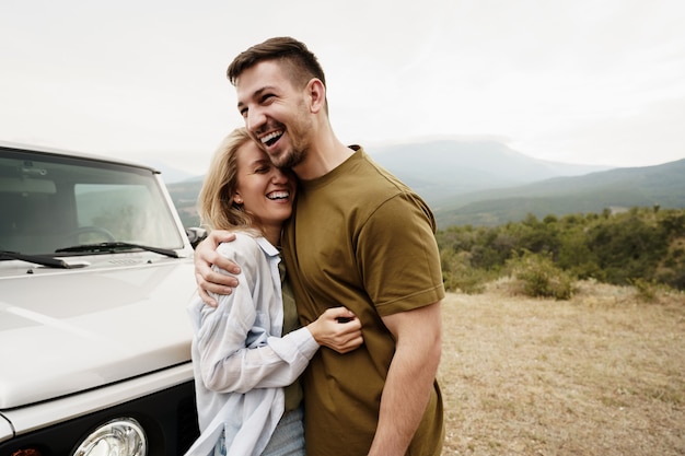 Foto pareja joven está en viaje romántico a las montañas en coche