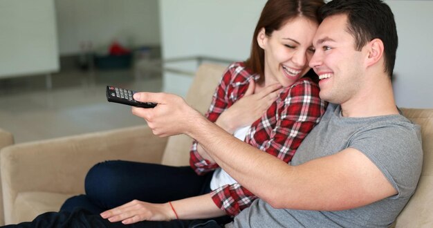 Pareja joven viendo la televisión en la sala de estar