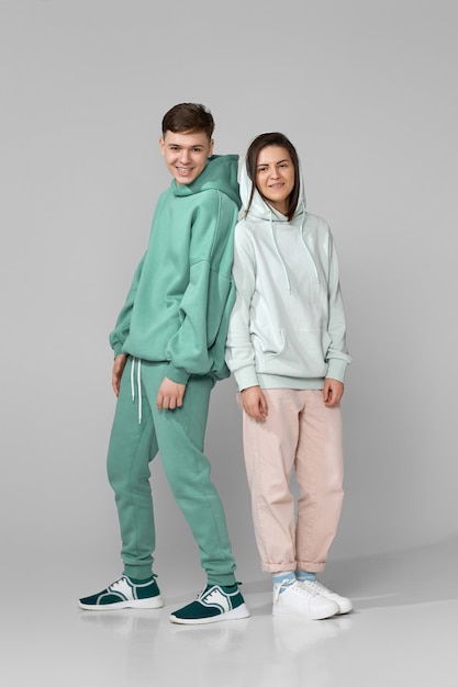 Pareja joven vistiendo sudadera con capucha casual verde menta