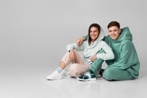 Foto pareja joven vistiendo sudadera con capucha casual verde menta