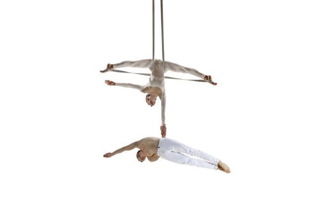 Foto pareja de jóvenes acróbatas, atletas de circo aislados sobre fondo blanco de estudio.