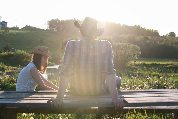 Pareja de jóvenes admira la puesta de sol en la tarde de primavera