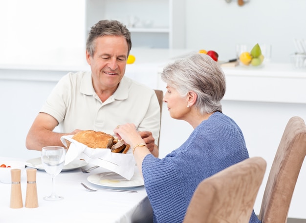 Pareja de jubilados comiendo en la cocina