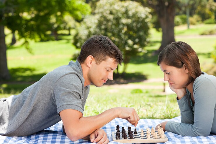 Foto pareja jugando al ajedrez en el parque