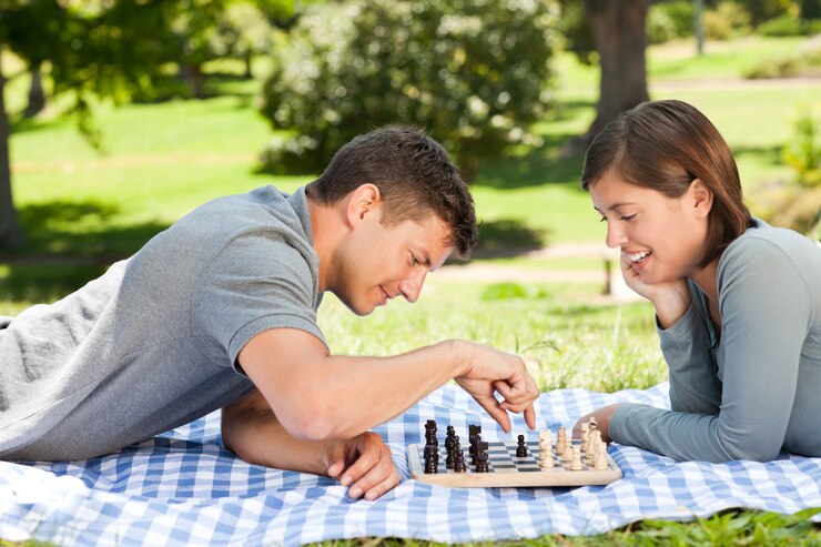 Foto pareja jugando al ajedrez en el parque