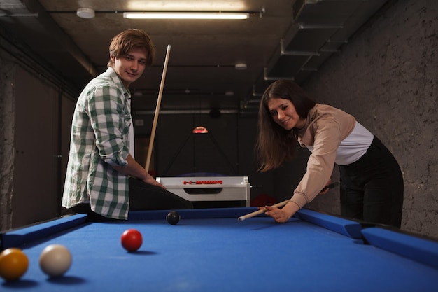 Pareja jugando al billar en una mesa de billar