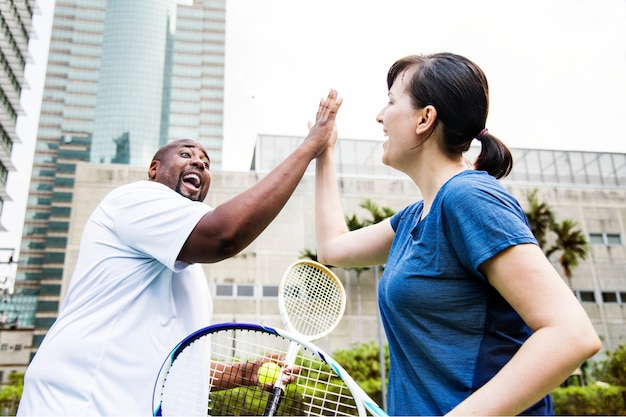 Pareja jugando al tenis como un equipo