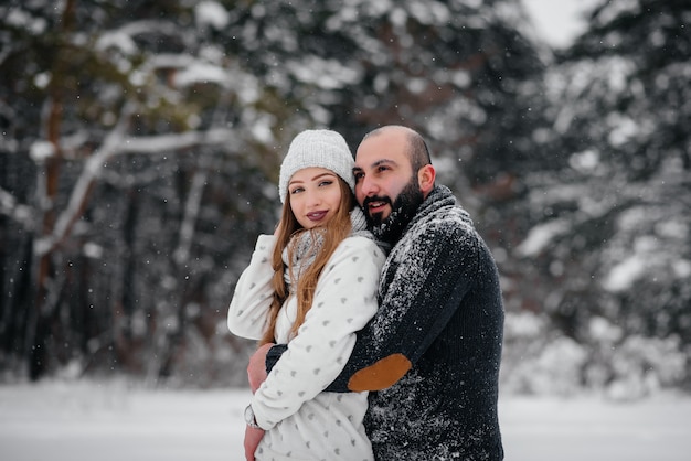 Pareja jugando con nieve en el bosque