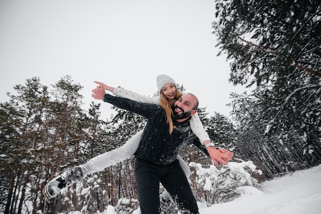 Pareja jugando con nieve en el bosque